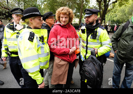 Westminster, London, UK - Monday 7th October 2019 - Extinction Rebellion XR climate protesters block roads around Westminster - Police officers arrest a protester at Millbank near Parliament. Photo Steven May / Alamy Live News Stock Photo