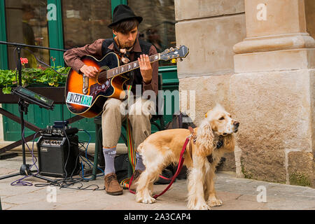 Lviv, Ukraine - May 04, 2019: Retro cross-country bicycles dedicated to the day of the city.Street musician with a dog playing a melody . Stock Photo