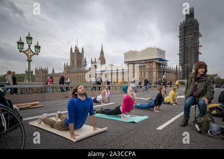 Extinction Rebellion morning yoga sessions on an occupied Westminster Bridge. The environmental campaigners begin a two week new wave of protest action causing disruption at key sites in London including Westminster Bridge, Lambeth Bridge, Trafalgar Square, Parliament areas and Smithfield market as well as several road blockades. The Metropolitan Police have confirmed over 1500 arrests to date. London, UK. Stock Photo