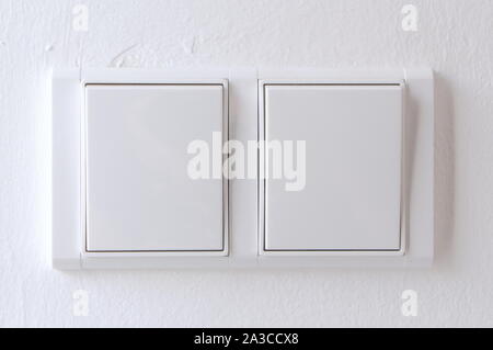 Two white switches on the wall of an house Stock Photo