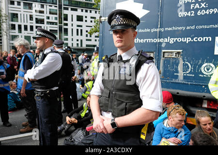 Westminster, London, UK - Monday 7th October 2019 - Extinction Rebellion XR climate protesters block Marsham Street directly outside the Home Office - the protesters parked a lorry across the road and several have then glued themselves to the vehicle - Police watch on. Photo Steven May / Alamy Live News Stock Photo