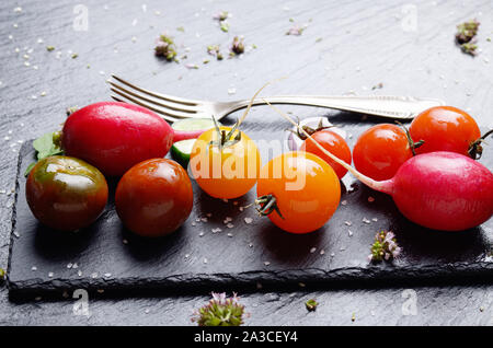Fresh organic vegetables on slate stone tray with spices aside closeup dark concept photo Stock Photo