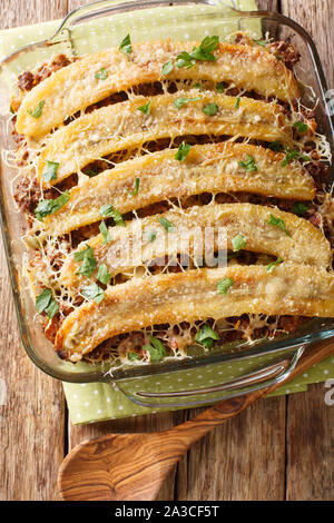 puerto rican sweet plantain lasagna with ground beef, cheese and dried fruits close-up in a baking dish on the table. Vertical top view from above Stock Photo