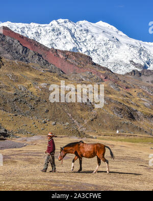 Horsemen in traditional Quechua dress following trails through the Andes. Ausangate trail, Cusco, Peru Stock Photo