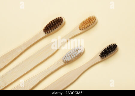 Four eco-friendly bamboo toothbrushes on a yellow background. Zero waste concept, plastic-free, organic, eco-friendly shopping Stock Photo