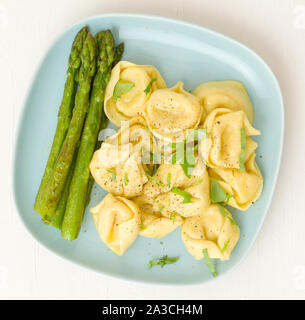 Ravioli with asparagus on a blue plate Stock Photo