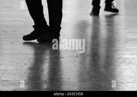 Legs and shadows of people on pavement Stock Photo