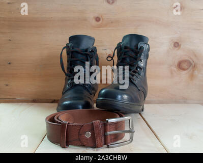 classic black shoes and belt on wooden table. Stock Photo