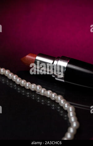 Red Lipstick with Pearl Necklace on Glass Stock Photo