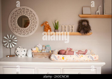 Newborn baby girl laying on changing table in diaper at home Stock Photo