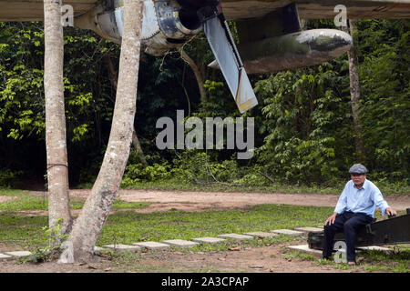 Cambodia, Vietnam, April 10, 2019: Old man standing close to a fighter plane in Vietnam, 2019 Stock Photo