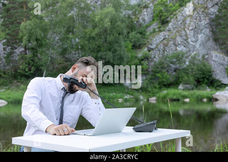 Frustrated, displeased young bearded man, guy. Trying to focus on work and tired of office work. Stock Photo