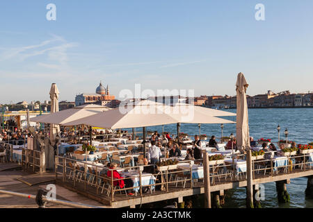 Restorante Terazza dei Nobili, Zattere, Dorsoduro, Venice, Veneto,  italy with tourists eating on a deck on the Giudecca Canal at sunset Stock Photo