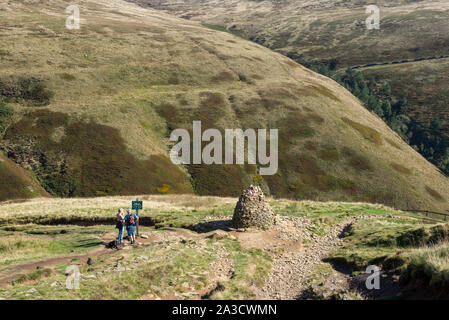 Walkers by a stone cairn at Jacobs Ladder on the Pennine Way, Edale, Peak District, Derbyshire, England. Stock Photo