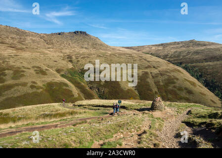 Walkers by a stone cairn at Jacobs Ladder on the Pennine Way, Edale, Peak District, Derbyshire, England. Stock Photo