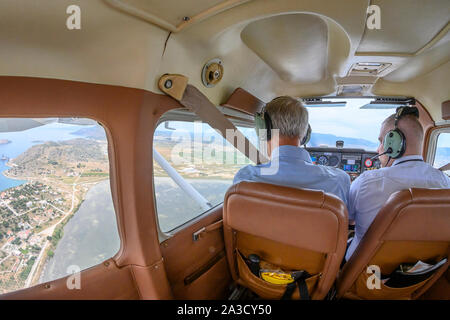 Pilot and co-pilot in a Cessna 172 airplane flying near Megara close to Athens, Attica, Greece Stock Photo