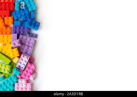 A lot of Colorful Plastick constructor bricks on white background. Popular toys. Copyspace Stock Photo