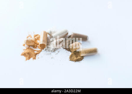 Herbal pills. Open capsules and powder on white background Stock Photo