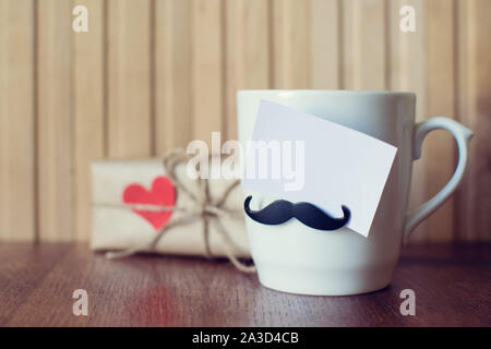 Greeting card on Cup with funny mustache over wooden board. Fathers day. Happy birthday. Valentines day. Mockup Stock Photo