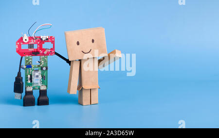 Metal and cardboard robots on blue panorama background Stock Photo