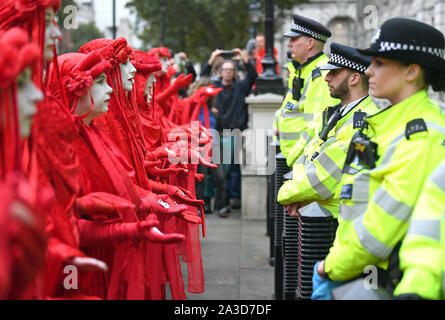 Protesters, dubbed the Red Rebels, outside the Cabinet Office on Whitehall, during an Extinction Rebellion (XR) protest in Westminster, London. Stock Photo