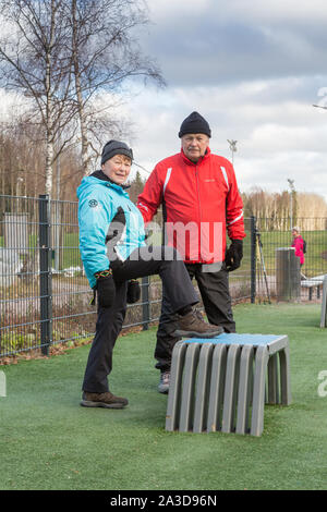 Elderly couple doing daily excercise at the outdoor gym Stock Photo