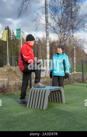 Elderly couple doing daily excercise at the outdoor gym Stock Photo