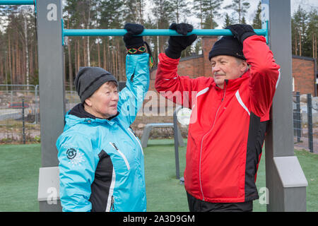 Elderly couple doing daily excercise at the outdoor gym Stock Photo