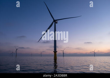 Dawn breaks over some of the 175 turbines on the London Array Offshore Wind Farm, which was the world's largest offshore wind farm until 2017 Stock Photo