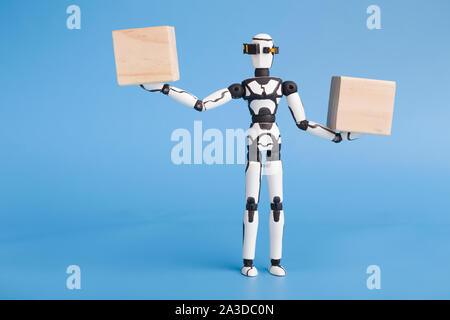 Robot holding two wooden cubes like on scales, comparing variants Stock Photo