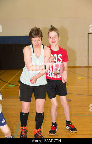 Group of disabled down syndrome men and women doing sports at indoor gym Stock Photo