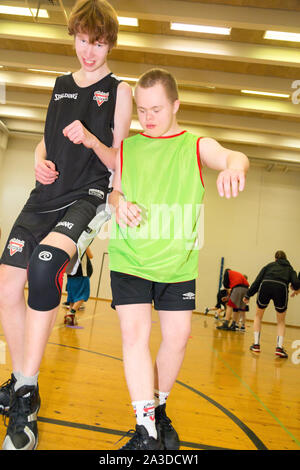 Group of disabled down syndrome men and women doing sports at indoor gym Stock Photo