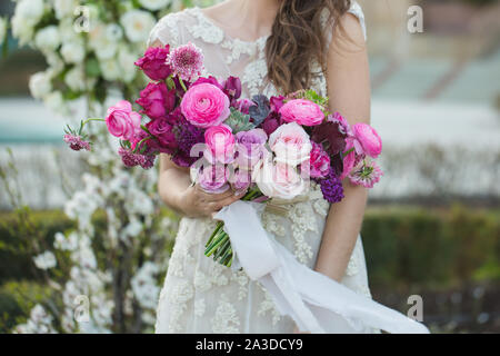Bride with beautiful wedding bouquet. Pink rose and other flowers. Stock Photo