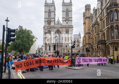 London, UK. 7th October 2019. XR banners in the road block in fron to Westminster Abbey. Extinction Rebellion begin the International Rebellion by occupying sites at eleven locations outside government ministries, Downing St, The Mall, Westminster and Lambeth bridges, bringing traffic to a halt. They demand the government tell the truth about the climate and ecological emergency, act to halt biodiversity loss, reduced emissions to net zero and create and be led by a Citizens Assembly. Peter Marshall/Alamy Live News Stock Photo