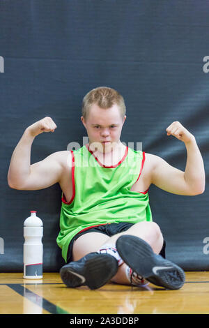 Group of disabled down syndrome men and women doing sports at indoor gym Stock Photo