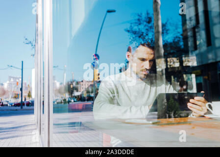 Young man using tablet computer in cafe Stock Photo