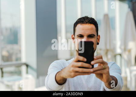 Young man taking a selfie with smartphone Stock Photo