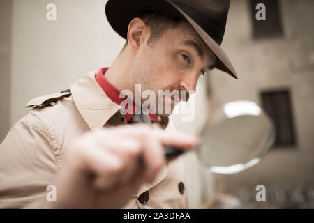 Vintage detective using a magnifying glass Stock Photo