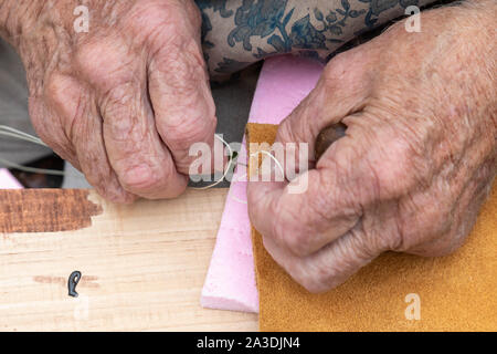 Detroit, Michigan - An elderly woman uses the two-needle baseball stitch to make moccasins as the Ste. Anne Parish de Detroit holds its third annual R Stock Photo