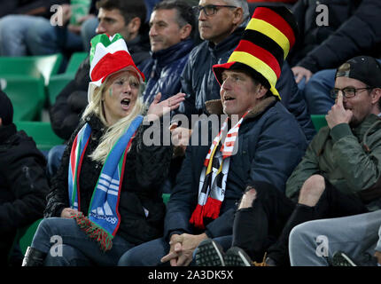 07 October 2019, Bavaria, Fürth: Soccer: DFB-All-Stars against Italy in the Sportpark Ronhof Thomas Sommer. Two fans with hats in the national colours of Italy and Germany follow the game. Photo: Daniel Karmann/dpa Stock Photo