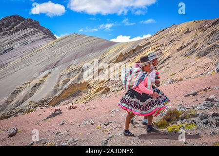 Two young Quechua girls follow trails in the Andes on the Ausungate trek. Cusco, Peru Stock Photo