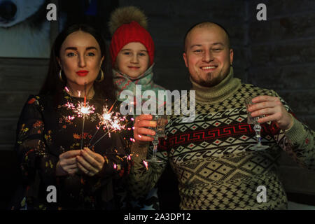 family celebrating with wine glasses and sparklers Stock Photo