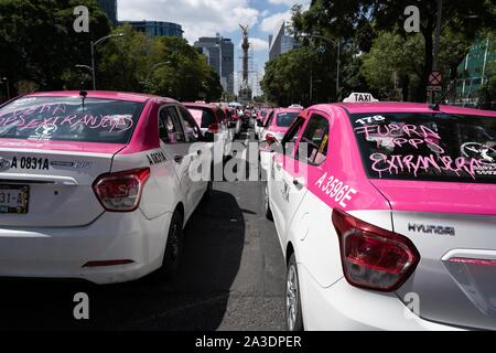Thousands of taxis are seen parked on the roads around the statue of the Angel of Independence in Mexico City.  Slogans on the windscreens read ÔFuera Aplicacion extranjeroÕ (demanding removal of foreign applications). Photo credit: Lexie Harrison-Cripps Stock Photo