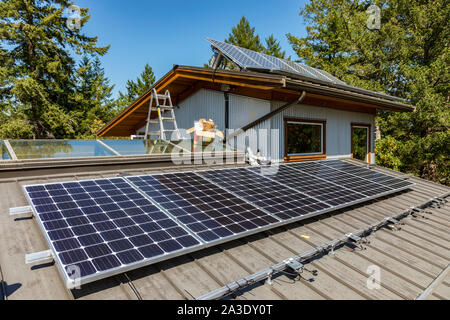 Solar photovoltaic panel installation on a homeowners roof in British Columbia, Canada. Stock Photo