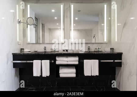 Stylish twin bathroom with two sinks and mirror. Stock Photo