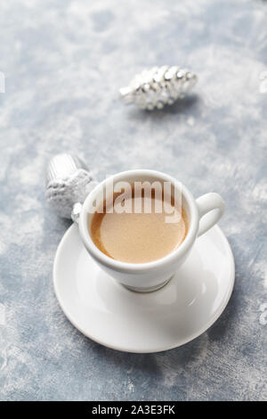 Cup of coffee and silver Christmas baubles on bright wooden background. Copy space. Stock Photo