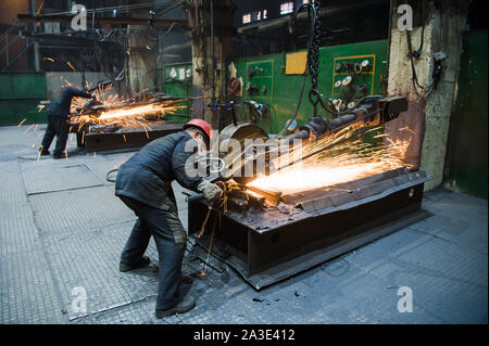 NIZHNY NOVGOROD, RUSSIA - OCT 7, 2017: Industrial workers with work tool. Big chainsaw in hands at steel factory. Stock Photo