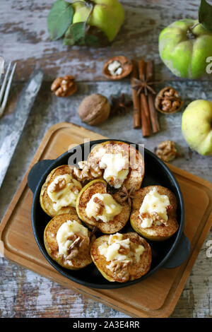 Baked quince with sweet cheese, cinnamon and nuts. Healthy dessert. Keto diet. Stock Photo
