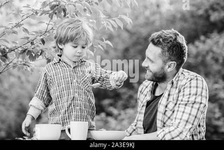Little boy and dad eat. Organic nutrition. Healthy nutrition concept. Nutrition habits. Family enjoy homemade meal. Personal example. Nutrition kids and adults. Father teach son eat natural food. Stock Photo