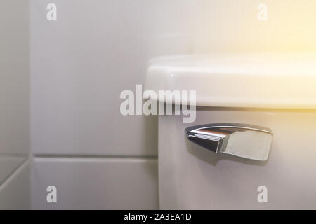 Toilet metal wc valve handle isolated on gray stone cement wall in bathroom . Faucet copy paste screen background Stock Photo